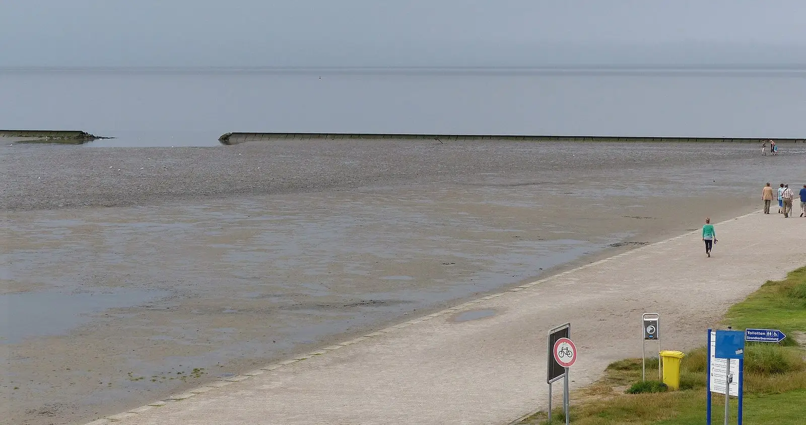 Hundestrand in Norddeich: befestigter Strandweg am Watt mit Hundekotbeutel-Spender