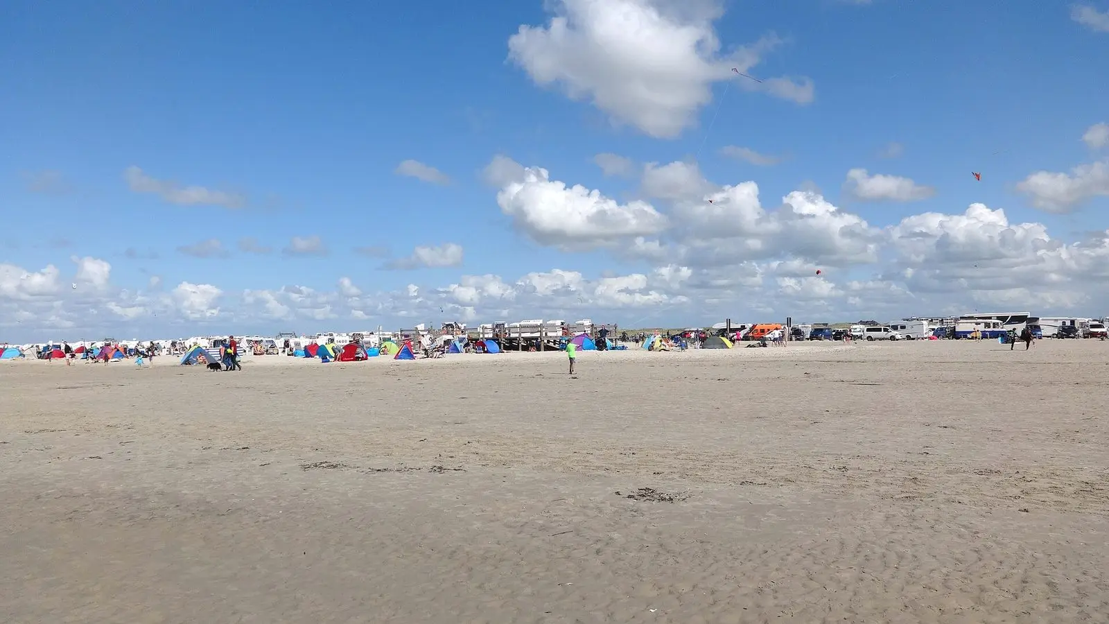 Breiter Strand vor Nord-Ording mit Strandkorb- und Wohnmobilbereich in der Ferne