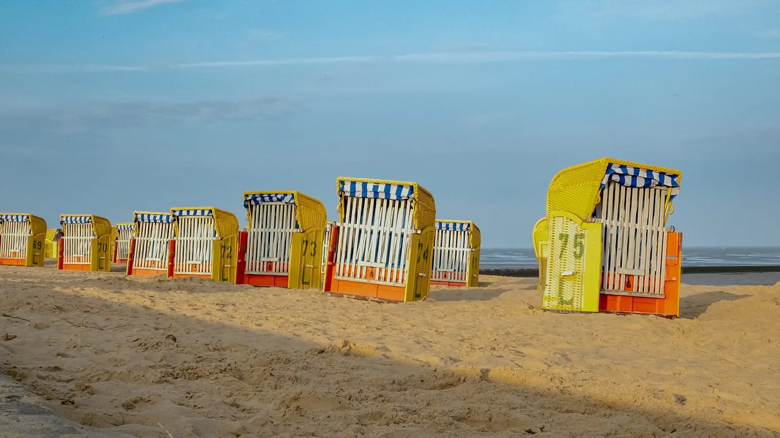 Bunte Strandkörbe am Sandstrand von Döse in der Abendsonne