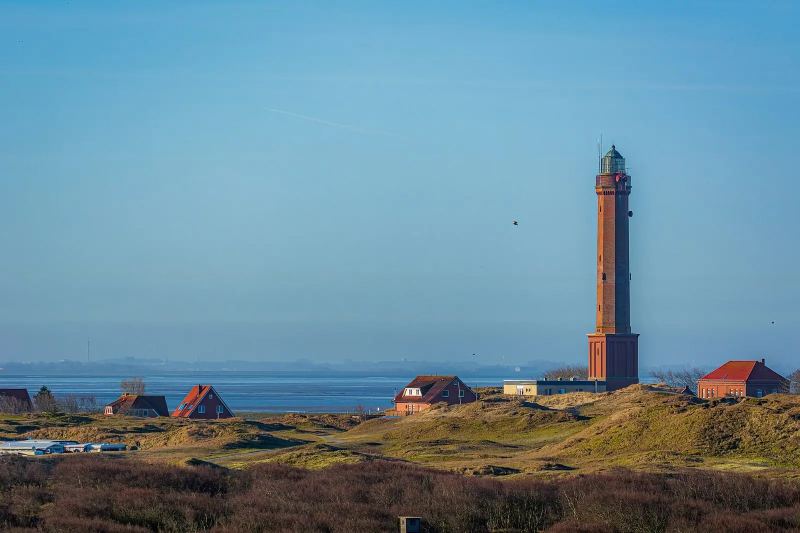 Blick über die Dünen auf den Backstein-Leuchtturm von Norderney