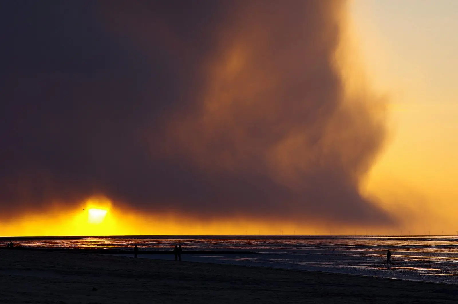 Dramatischer Sonnenuntergang mit Wolkenwand über dem Wattenmeer bei Cuxhaven
